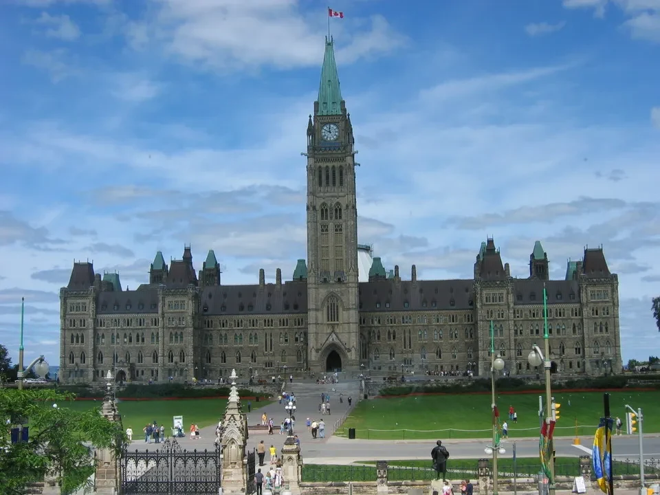 Vista frontale degli imponenti edifici del Parlamento di Ottawa con il Palazzo del Parlamento al centro.