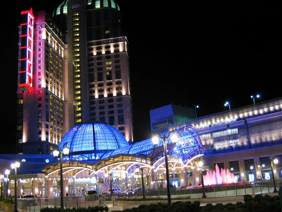 Veduta notturna di un edificio moderno con una cupola e una struttura vetrata illuminata.