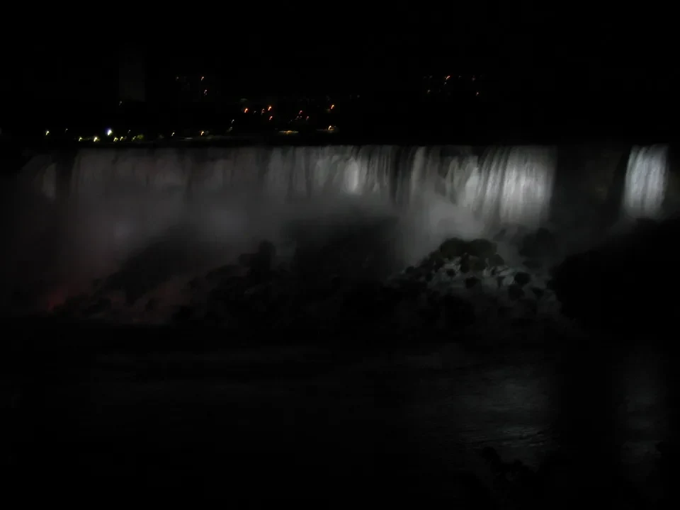 Una fotografia a lunga esposizione mostra una cascata nebbiosa di notte.