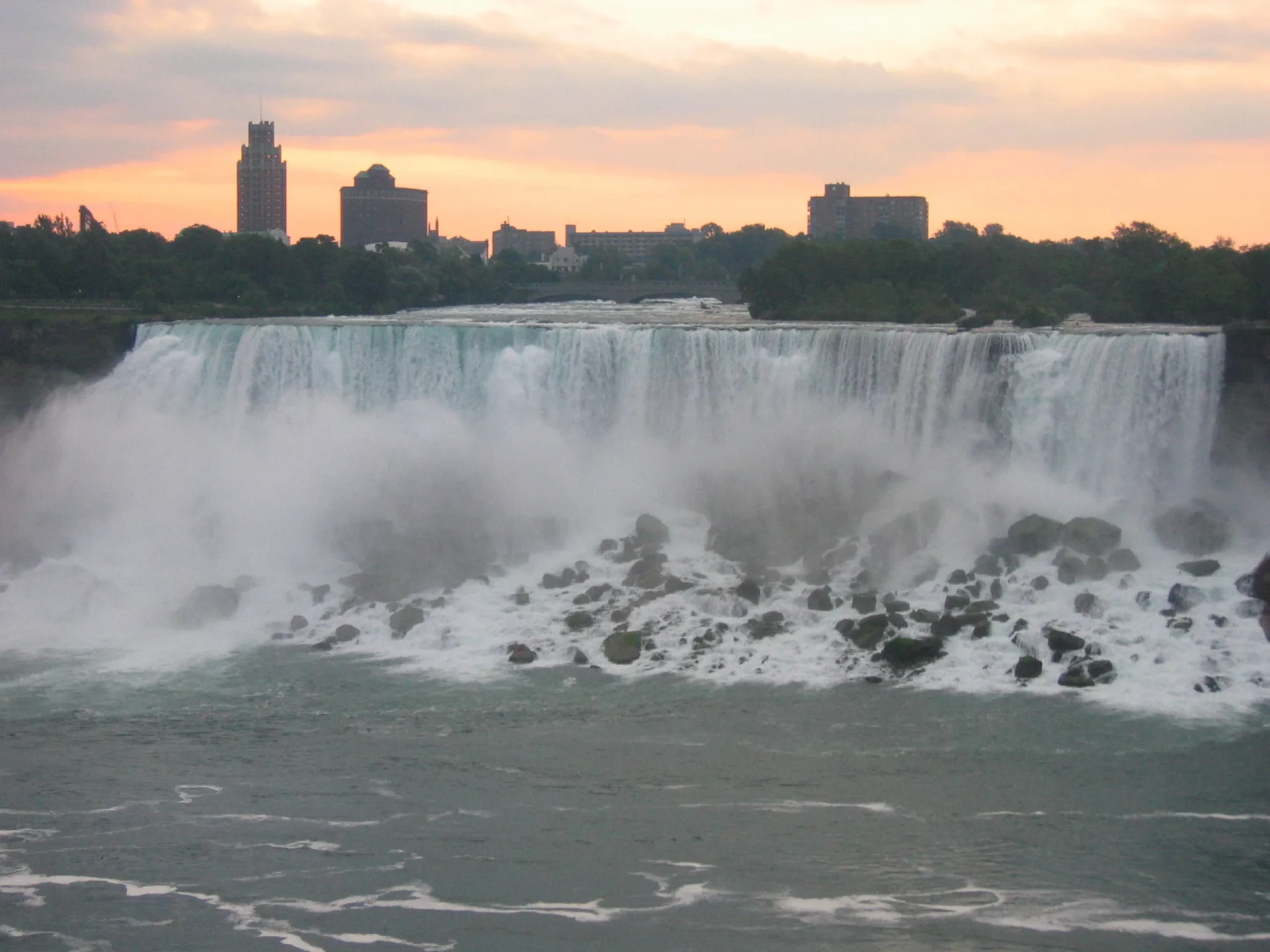 Cascata del Niagara al tramonto con la città sullo sfondo.