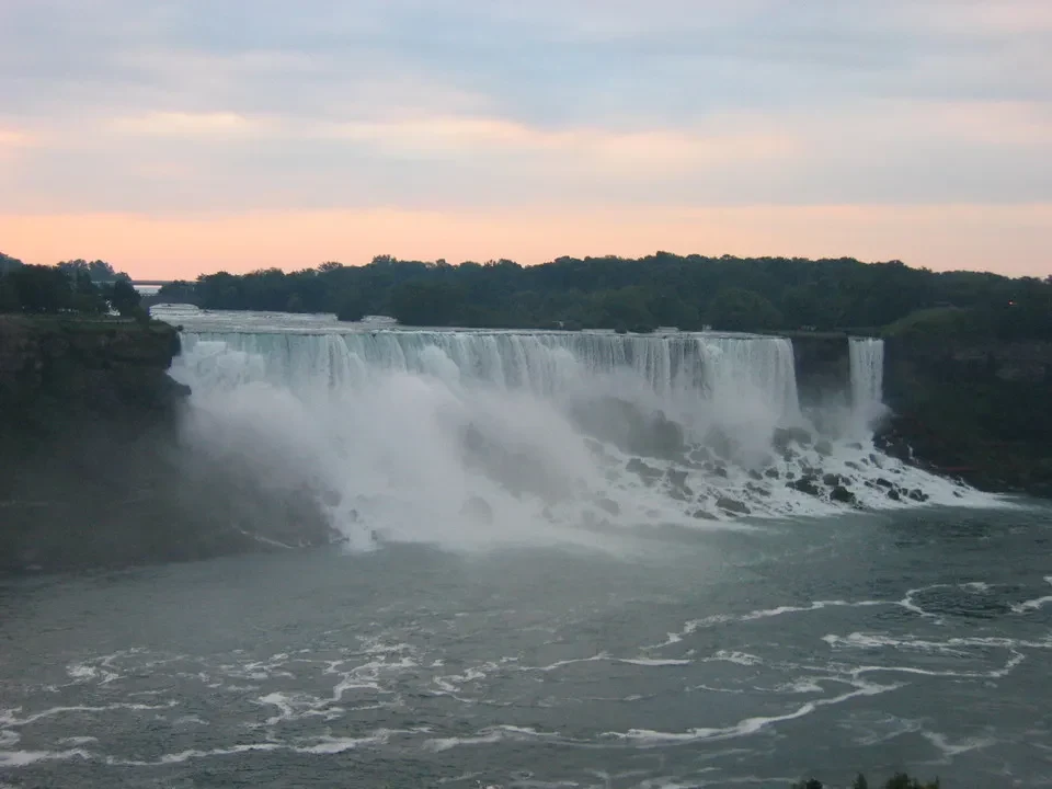 Cascata del Niagara al tramonto con la foresta sullo sfondo.