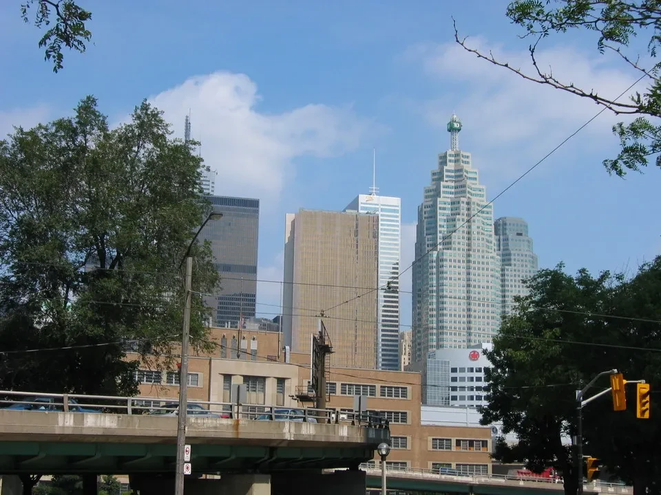 Paesaggio urbano di Toronto con edifici alti e alberi in primo piano.