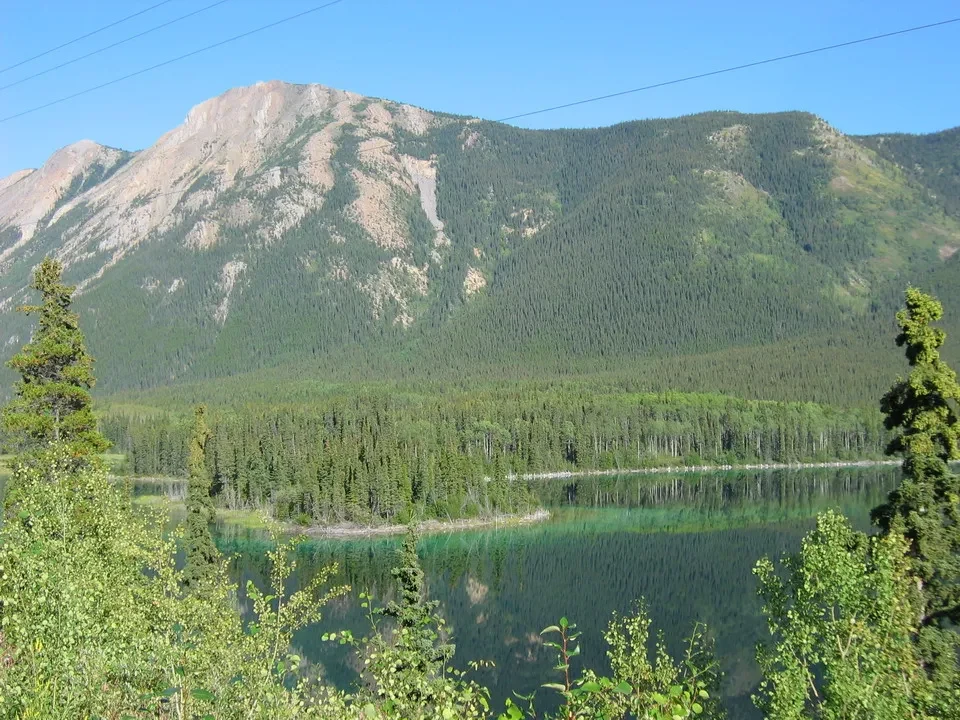 Paesaggio montano e boscoso lungo un lago in Canada Occidentale.