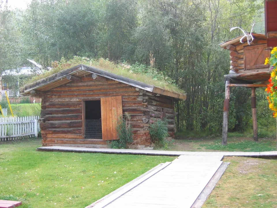 Una casa in legno con tetto erboso si trova in un ambiente rurale canadese.