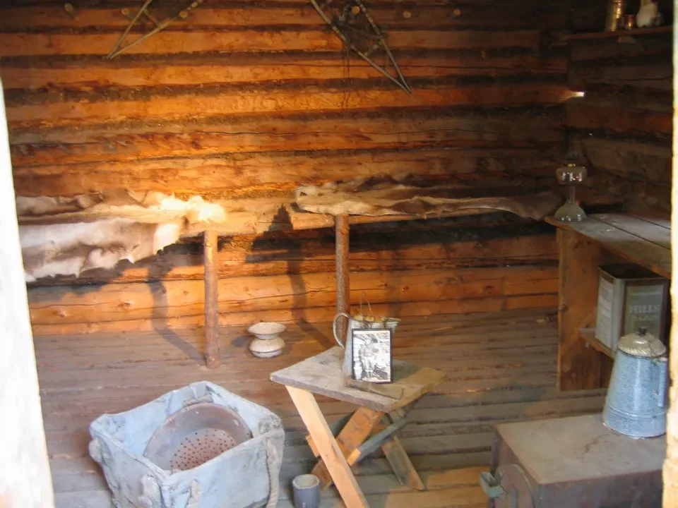 Interno rustico di una casa in legno con pareti a doghe orizzontali.