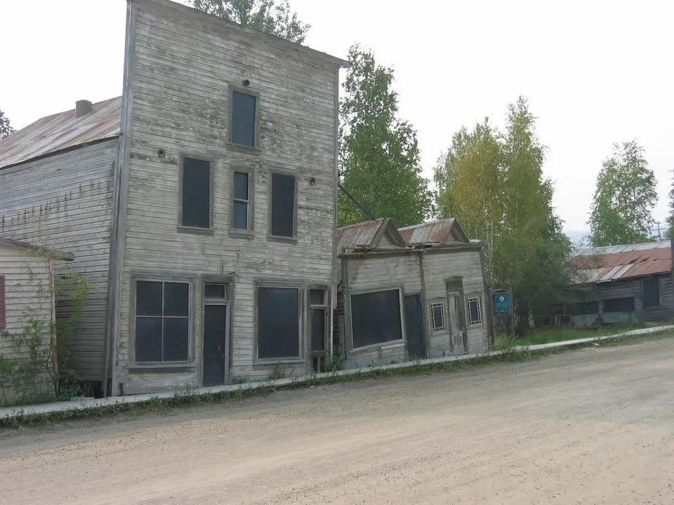 Un edificio in legno lungo una strada sterrata in Canada Occidentale.