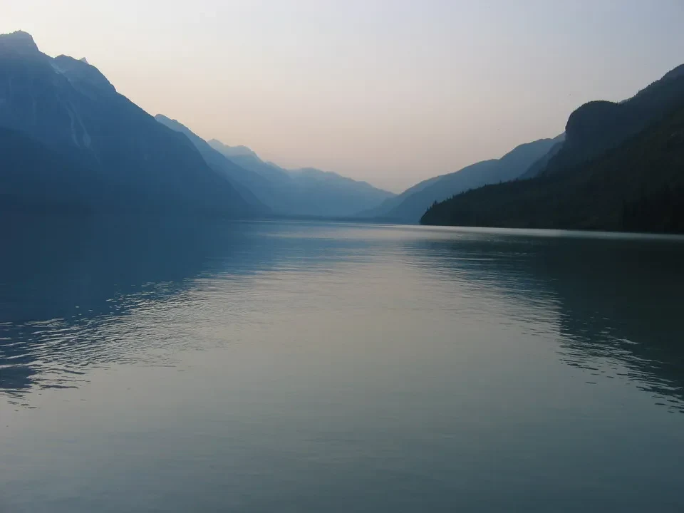 Un lago sereno è circondato da imponenti montagne al crepuscolo.