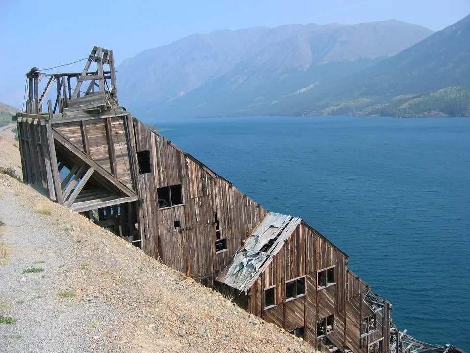 Struttura in legno di un vecchio impianto minerario lungo la riva dell'acqua.