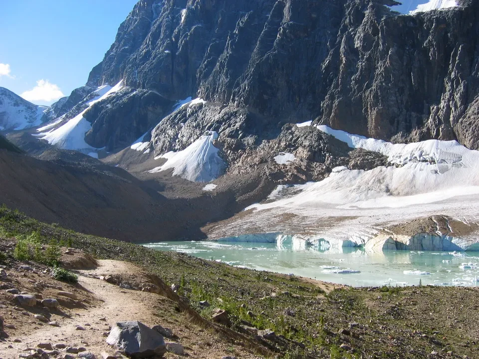 Paesaggio montano con un lago glaciale e neve nel Canada occidentale.