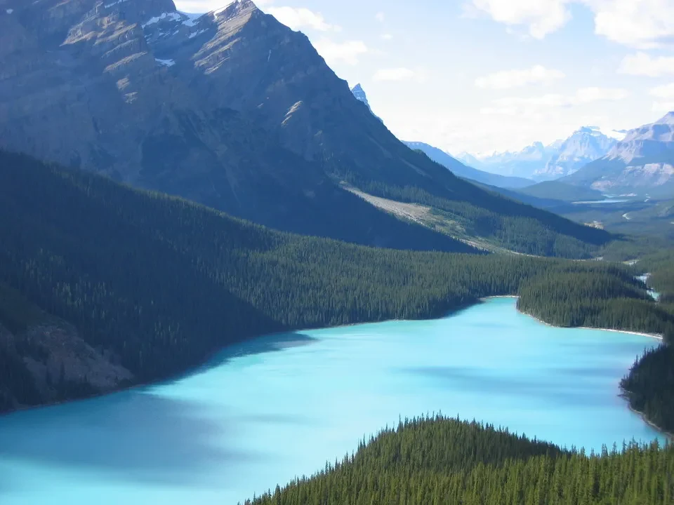 Un lago turchese circondato da montagne verdi e boschi in Canada occidentale.